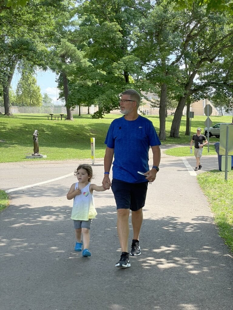 Mark walking hand in hand with his granddaughter